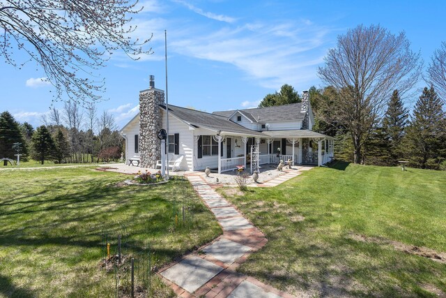 3121 Grace Rd, Frankfort, MI 49635 - back of property with a chimney, a porch, and a yard