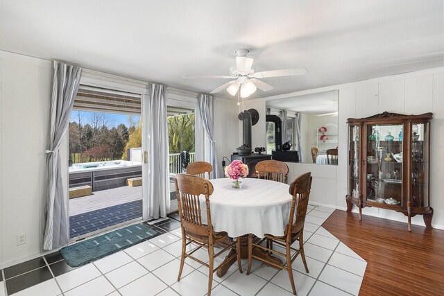 3121 Grace Rd, Frankfort, MI 49635 - dining space with a ceiling fan, a wood stove, and light wood-style floors