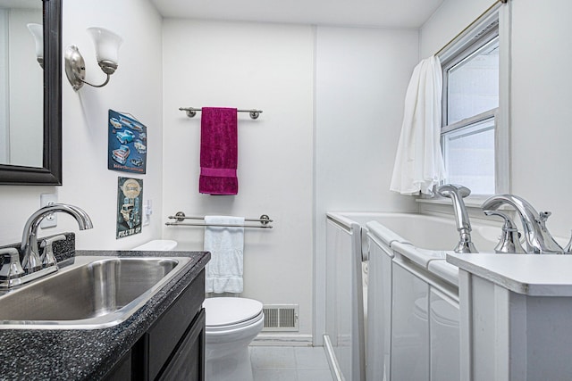 3121 Grace Rd, Frankfort, MI 49635 - bathroom with toilet, vanity, and tile patterned flooring