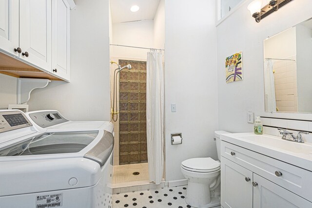 3121 Grace Rd, Frankfort, MI 49635 - full bathroom with washer and clothes dryer, tiled shower, toilet, vanity, and baseboards