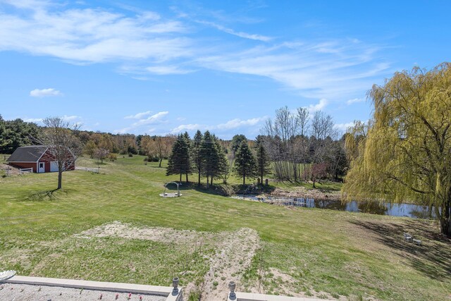 3121 Grace Rd, Frankfort, MI 49635 - view of green lawn with a water view, a wooded view, and an outbuilding