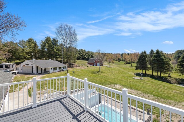 3121 Grace Rd, Frankfort, MI 49635 - wooden deck featuring a garage, a lawn, driveway, and an outdoor structure