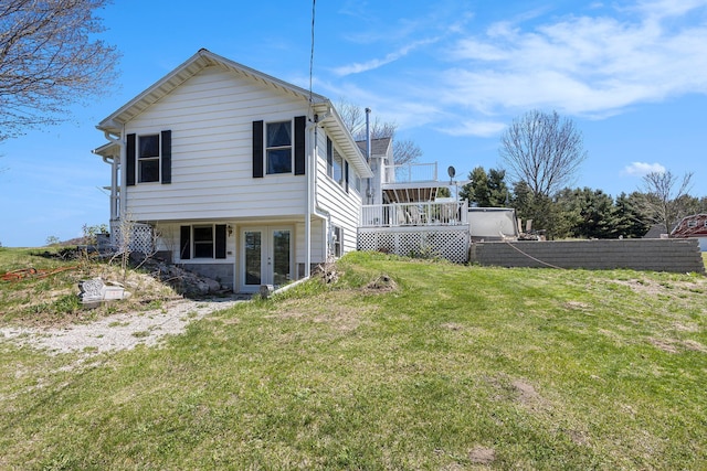 3121 Grace Rd, Frankfort, MI 49635 - rear view of house with french doors, a lawn, and a deck