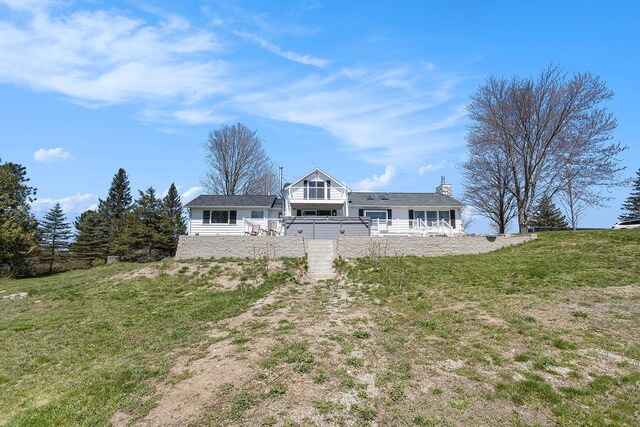 3121 Grace Rd, Frankfort, MI 49635 - rear view of property featuring stairs and a lawn