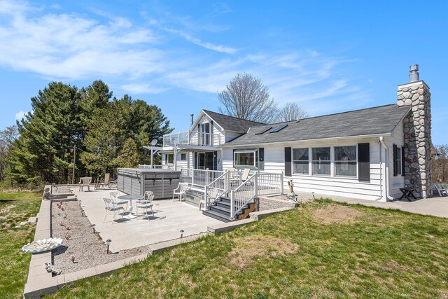 3121 Grace Rd, Frankfort, MI 49635 - rear view of house with a hot tub, a patio, a chimney, and a shingled roof