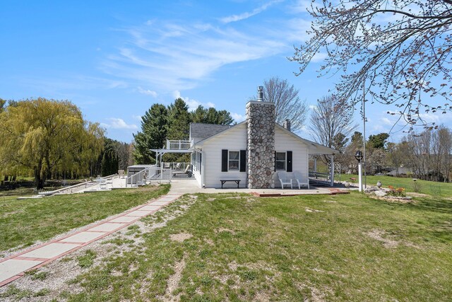 3121 Grace Rd, Frankfort, MI 49635 - rear view of property with a patio, a chimney, and a lawn