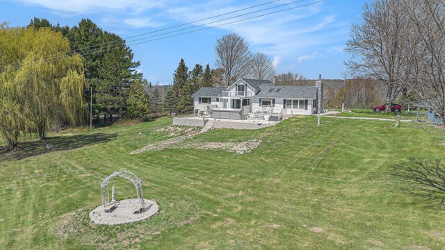 3121 Grace Rd, Frankfort, MI 49635 - rear view of property featuring a deck, a yard, and a view of trees