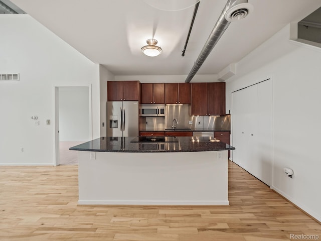 610 S Troy St, Royal Oak, MI 48067 - kitchen with stainless steel appliances, light wood-style flooring, a sink, dark stone counters, and a center island