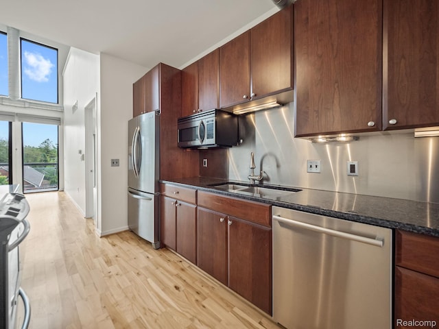 610 S Troy St, Royal Oak, MI 48067 - kitchen with stainless steel appliances, a sink, light wood-style flooring, dark stone countertops, and baseboards