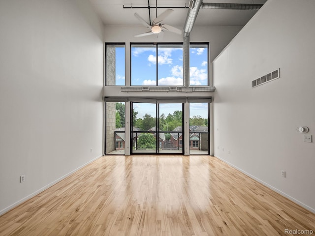 610 S Troy St, Royal Oak, MI 48067 - unfurnished living room featuring a towering ceiling, ceiling fan, wood finished floors, and baseboards