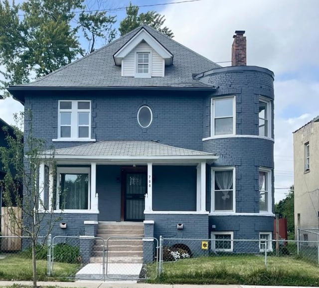 view of front of property with covered porch, a chimney, a fenced front yard, and brick siding