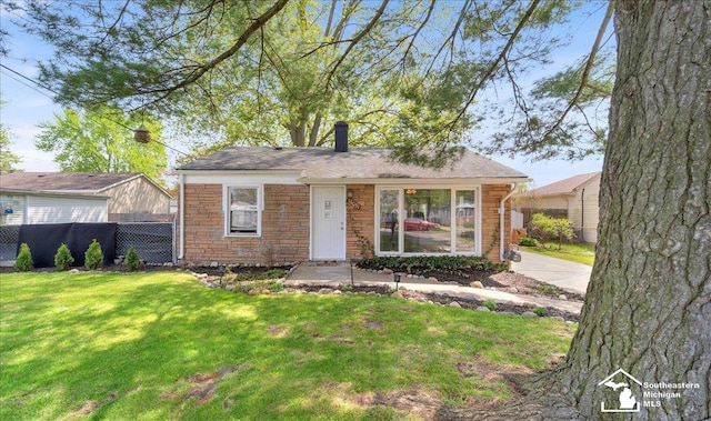 view of front of house with a chimney, a front lawn, fence, and stone siding