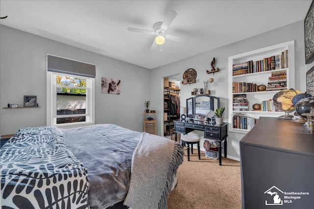 bedroom with carpet floors, ceiling fan, a spacious closet, and a closet