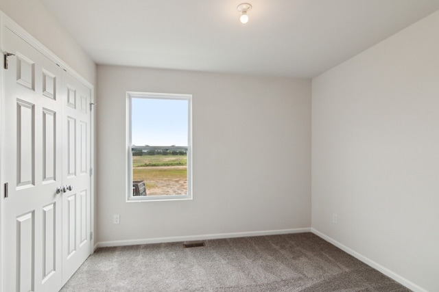 unfurnished bedroom with baseboards, carpet flooring, and visible vents