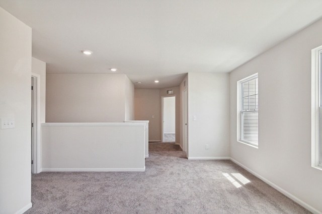 carpeted empty room featuring baseboards and recessed lighting