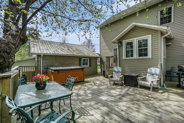 wooden deck featuring a hot tub and outdoor dining space