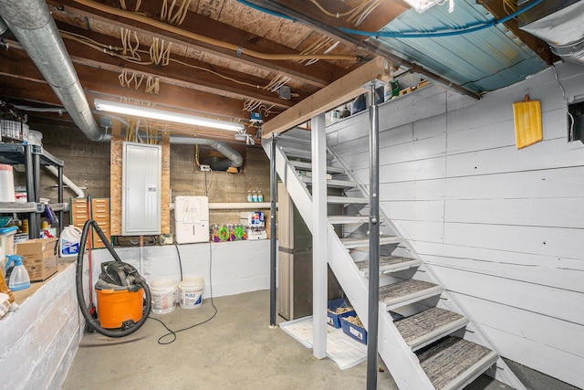 unfinished basement with stairs and electric panel