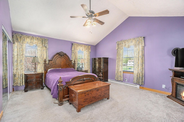 carpeted bedroom with ceiling fan, a glass covered fireplace, baseboards, lofted ceiling, and a baseboard radiator