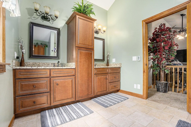 bathroom with baseboards, a notable chandelier, and vanity