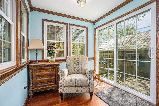 sunroom with baseboards, ornamental molding, and wood finished floors