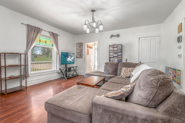 living area with baseboards, a notable chandelier, and wood finished floors