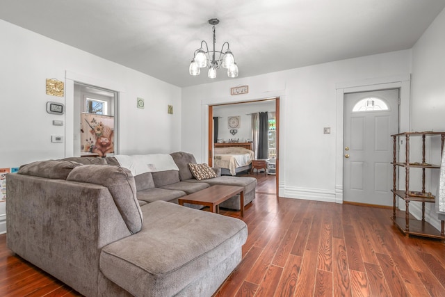 living area featuring baseboards, dark wood-style floors, and a chandelier