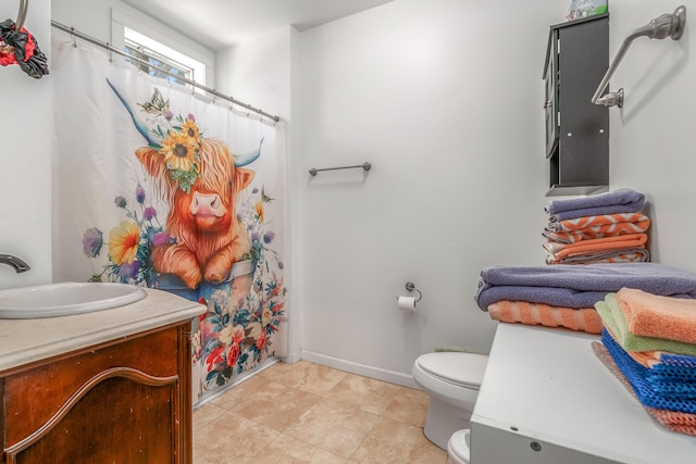 full bathroom featuring tile patterned flooring, curtained shower, vanity, baseboards, and toilet
