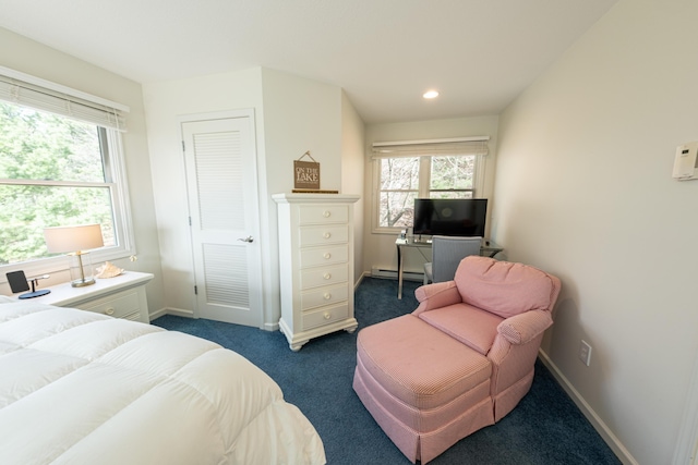 bedroom featuring baseboards, multiple windows, dark carpet, and a baseboard radiator
