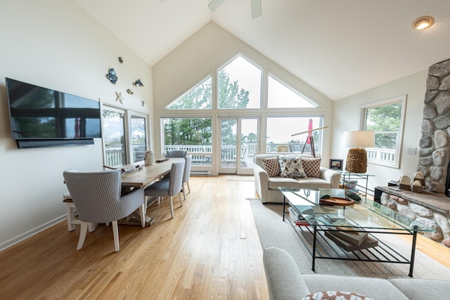 living room featuring light wood-style flooring, ceiling fan, and high vaulted ceiling