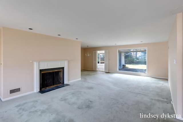 unfurnished living room featuring baseboards, visible vents, light carpet, and a fireplace with flush hearth