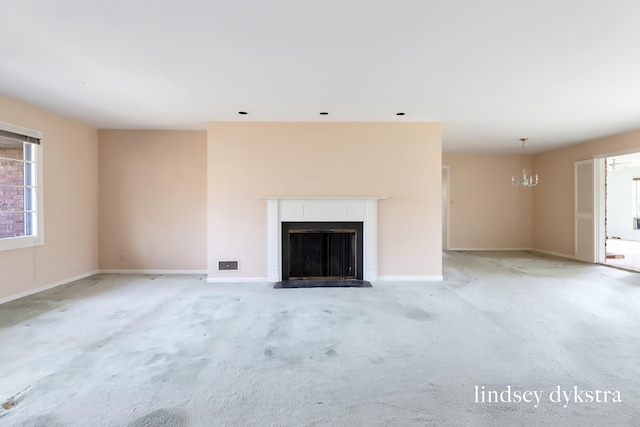 unfurnished living room featuring baseboards, a fireplace with flush hearth, a chandelier, and light carpet