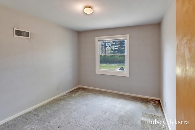 spare room with visible vents, carpet, and baseboards