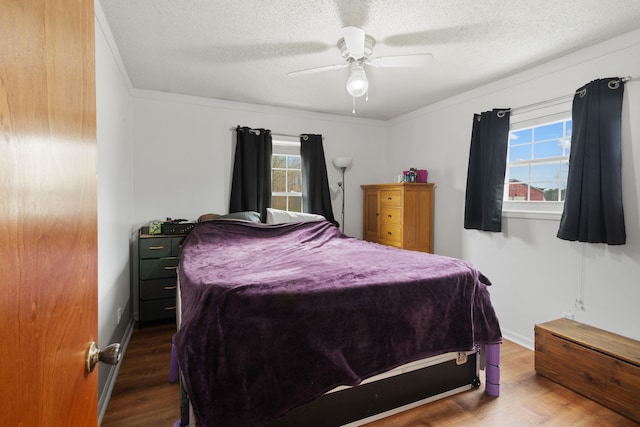 bedroom featuring crown molding, a ceiling fan, a textured ceiling, and wood finished floors