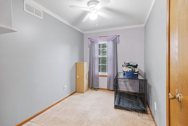 interior space featuring a ceiling fan, visible vents, ornamental molding, and carpet