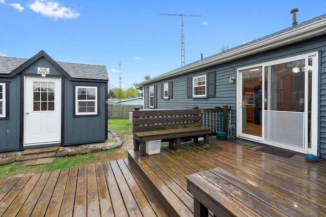 wooden deck featuring an outbuilding and a storage unit