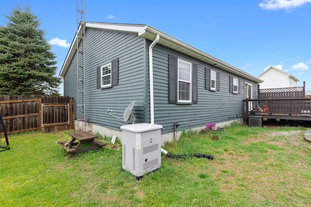 back of property featuring fence, a yard, and a wooden deck
