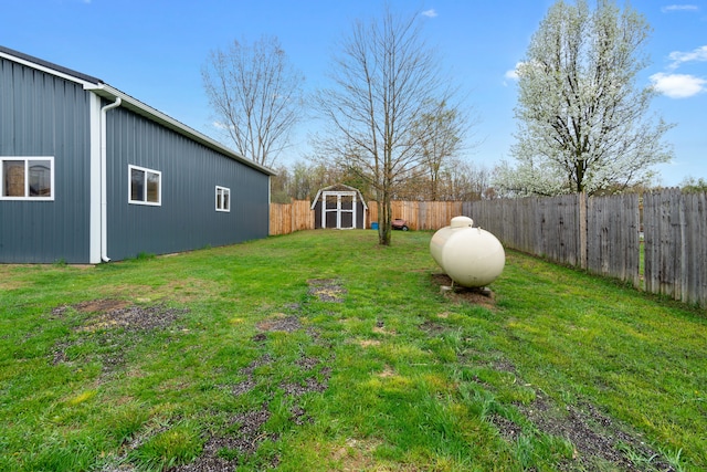 view of yard with a fenced backyard, an outbuilding, and a storage shed