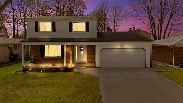 traditional-style home with a lawn, brick siding, driveway, and a garage
