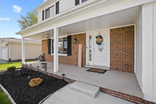 property entrance featuring a porch and brick siding