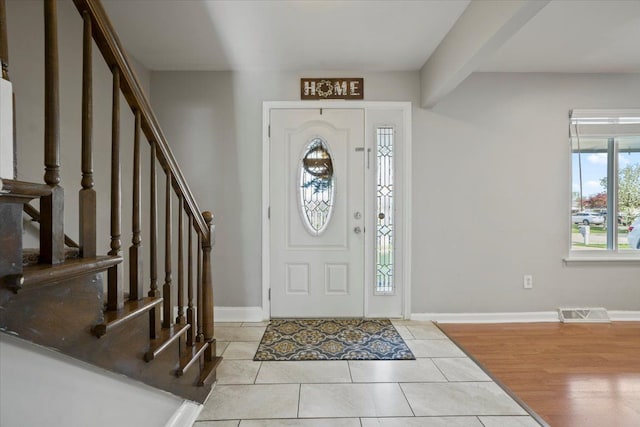 entryway featuring visible vents, baseboards, tile patterned floors, and stairway