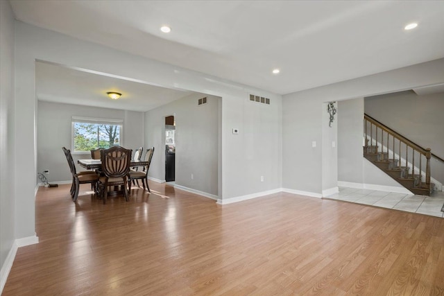 living room featuring light wood finished floors, stairs, recessed lighting, baseboards, and visible vents