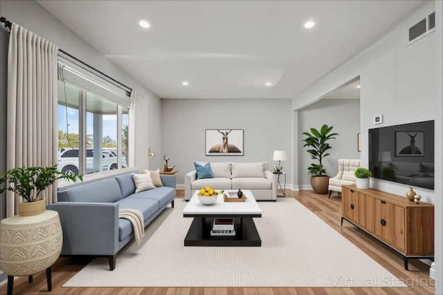living area featuring baseboards, recessed lighting, wood finished floors, and visible vents