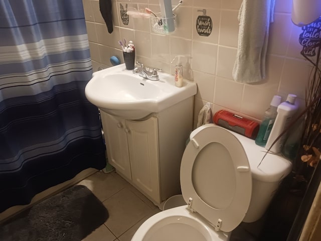 bathroom with vanity, tasteful backsplash, toilet, and tile walls