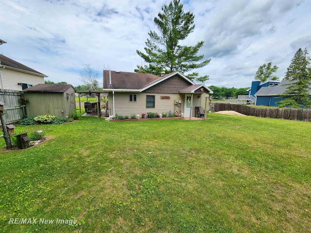 rear view of house featuring a fenced backyard, a lawn, and a shed