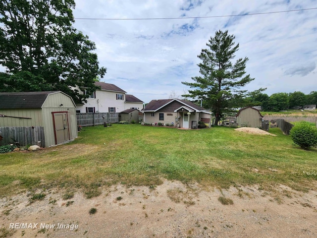 view of yard with a storage shed, fence, and an outdoor structure