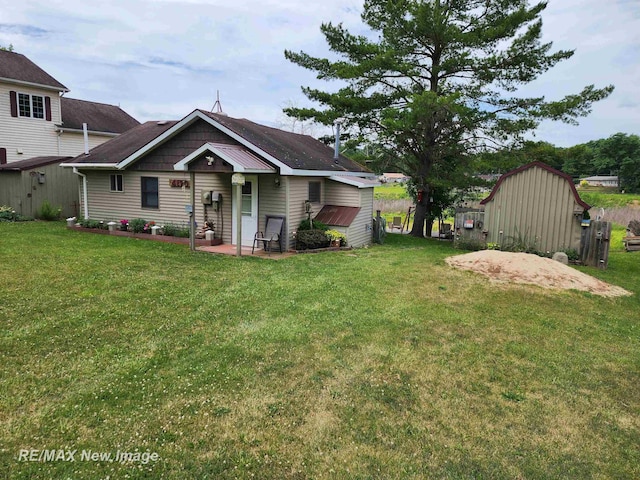 view of front of home featuring a storage unit, an outbuilding, and a front lawn