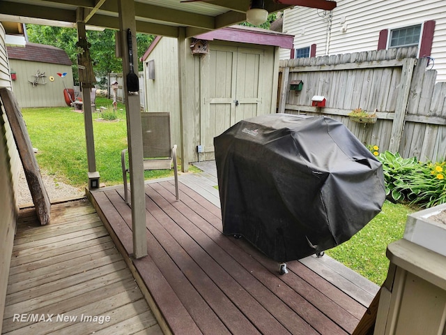 deck with fence, a storage unit, an outbuilding, and a yard