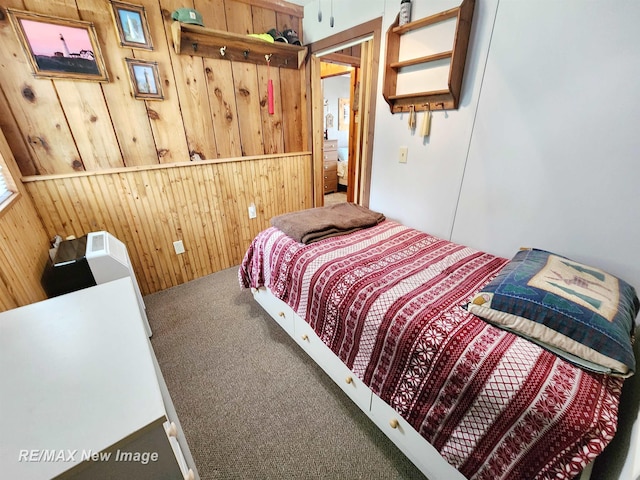 bedroom featuring carpet floors and wooden walls