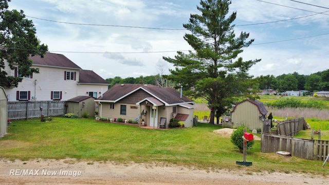 view of yard featuring fence, an outdoor structure, and a storage unit