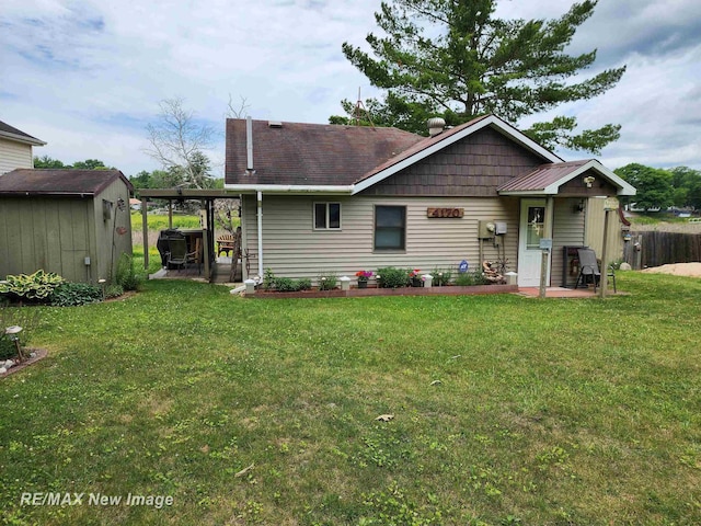 rear view of house with fence, a storage unit, an outdoor structure, a patio, and a yard